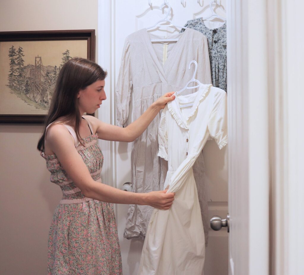 woman holding up handmade white dress