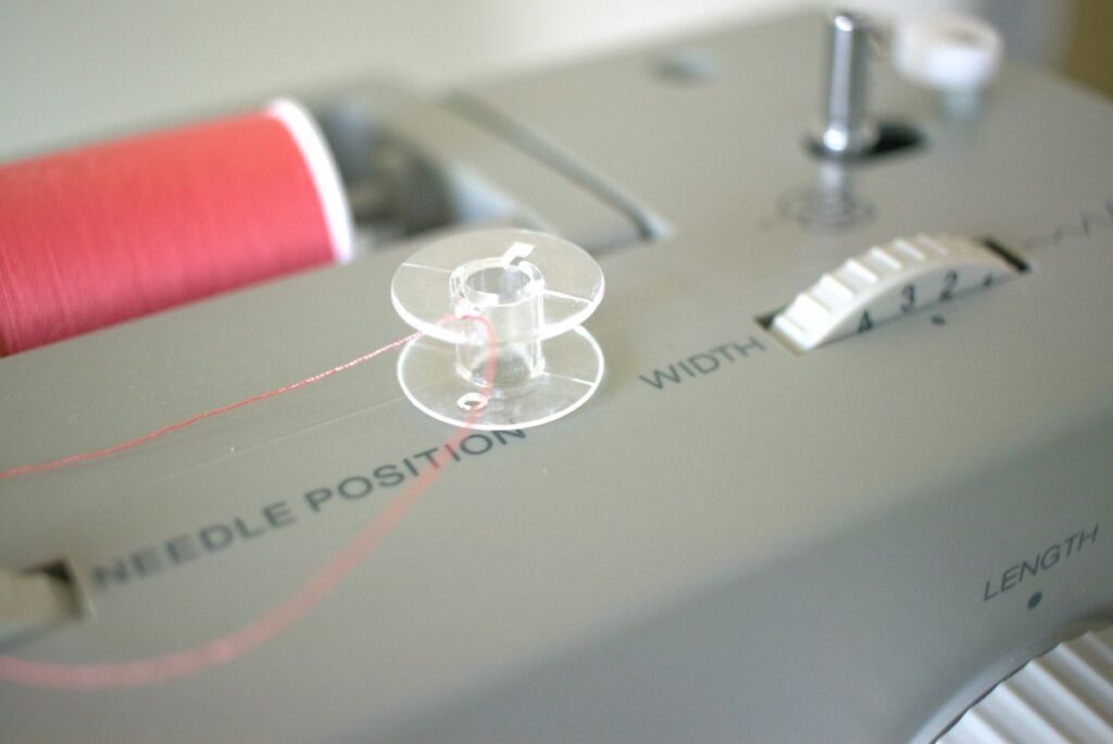 thread going through hole in the top of a bobbin