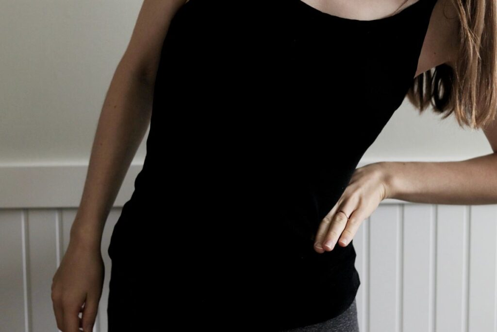 woman leaning to the side with hand pressing into her side