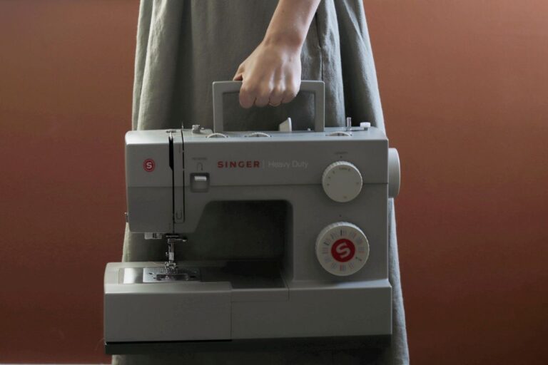 woman carrying singer sewing machine