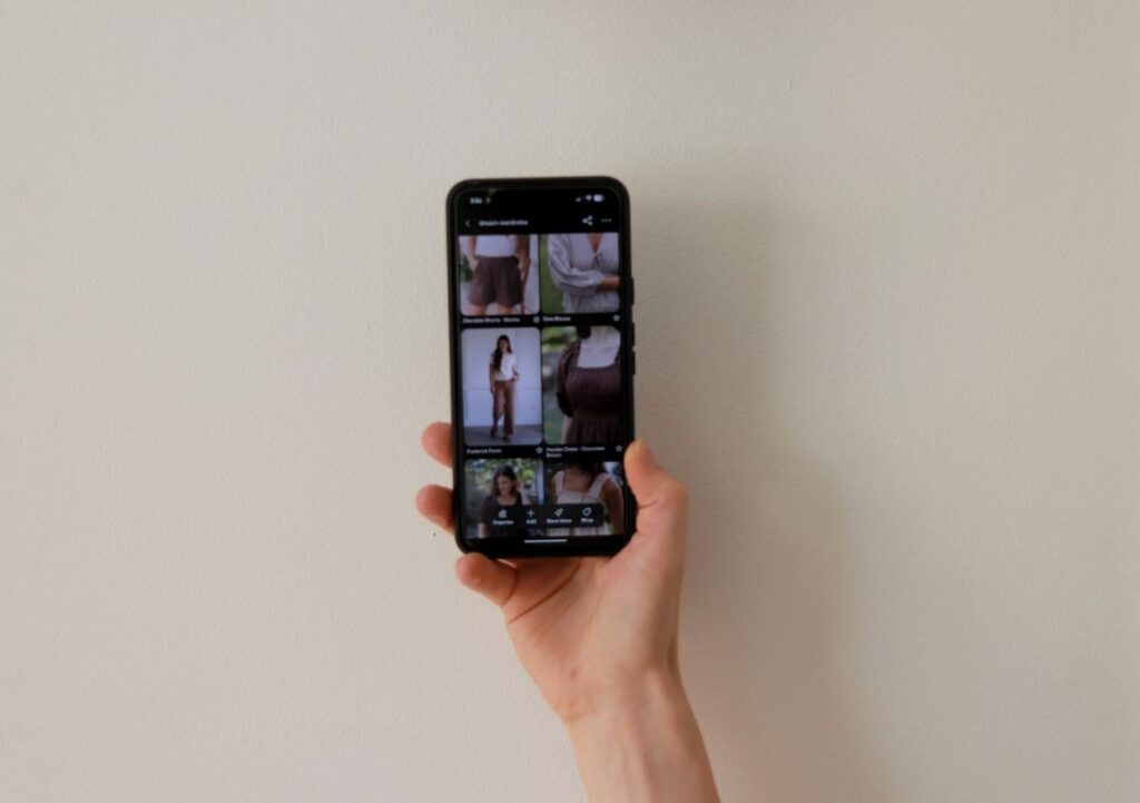 hand holding phone displaying a Pinterest clothing board