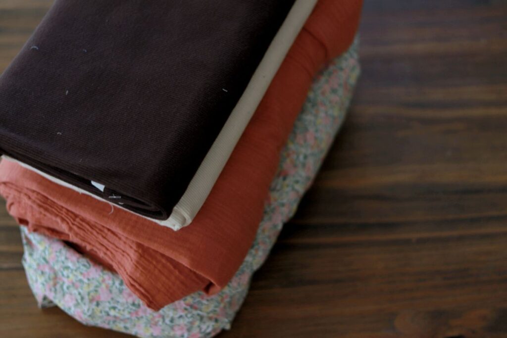 assorted fabrics neatly stacked on table