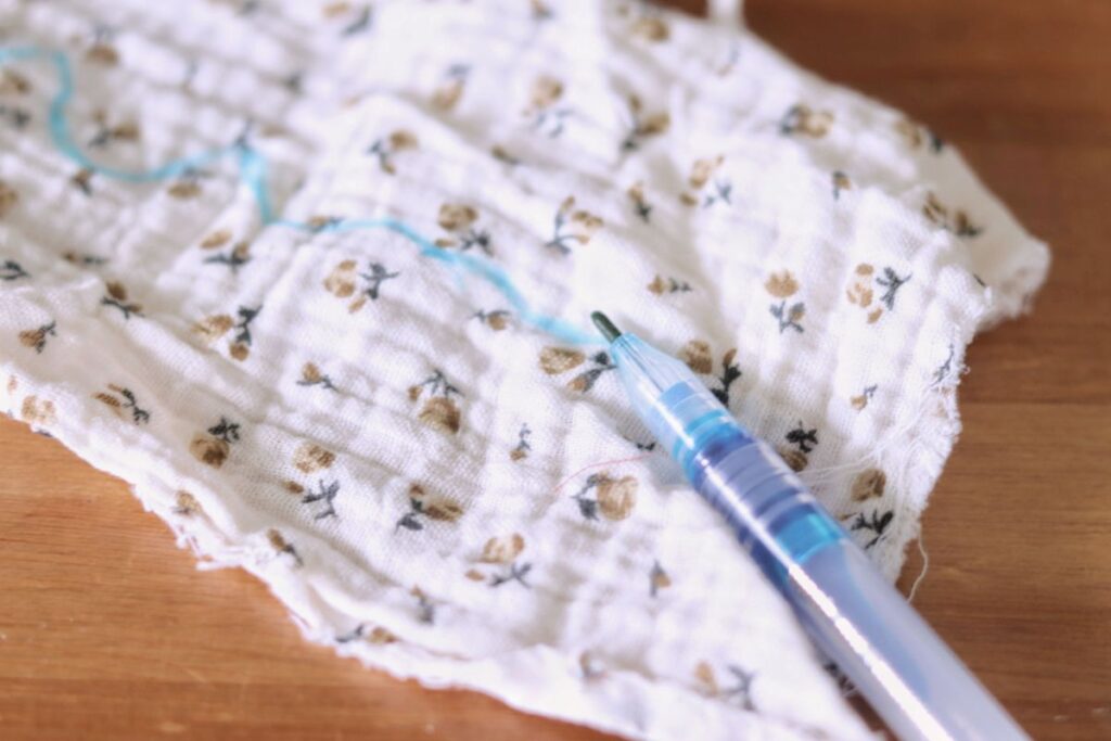 water erasable pen lying on fabric with blue pen mark