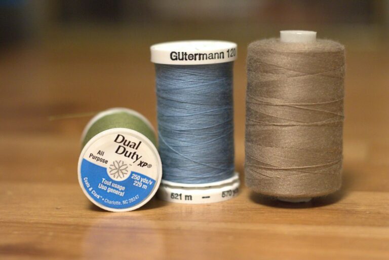 spools of different colored thread sitting and lying on a table