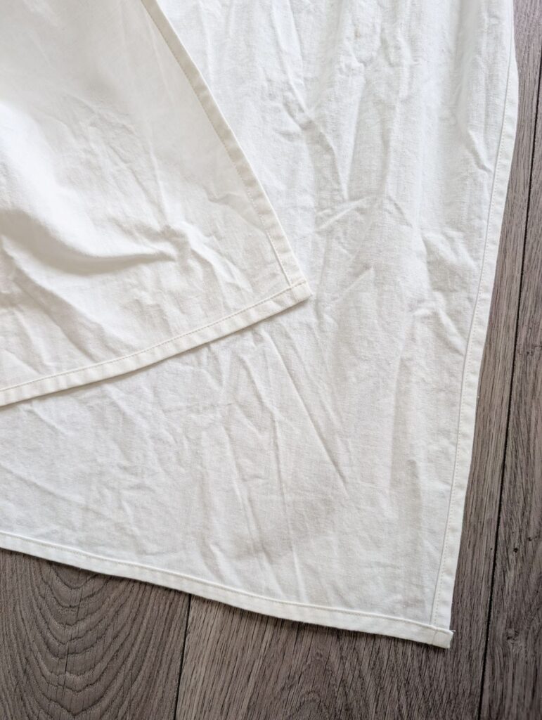 white diy curtain laying flat with hemmed edges