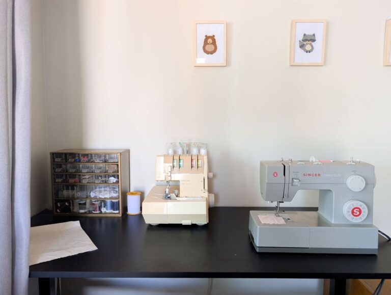 table with sewing machine, serger, and sewing supplies on it for slow sewing